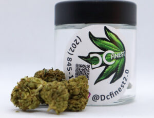 Close-up of a bright green bud with a clear, plastic contain from DC Finest in the background